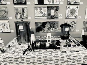 Black and white image of hot chocolate bar, tea and coffee on a Christmas tree print tablecloth